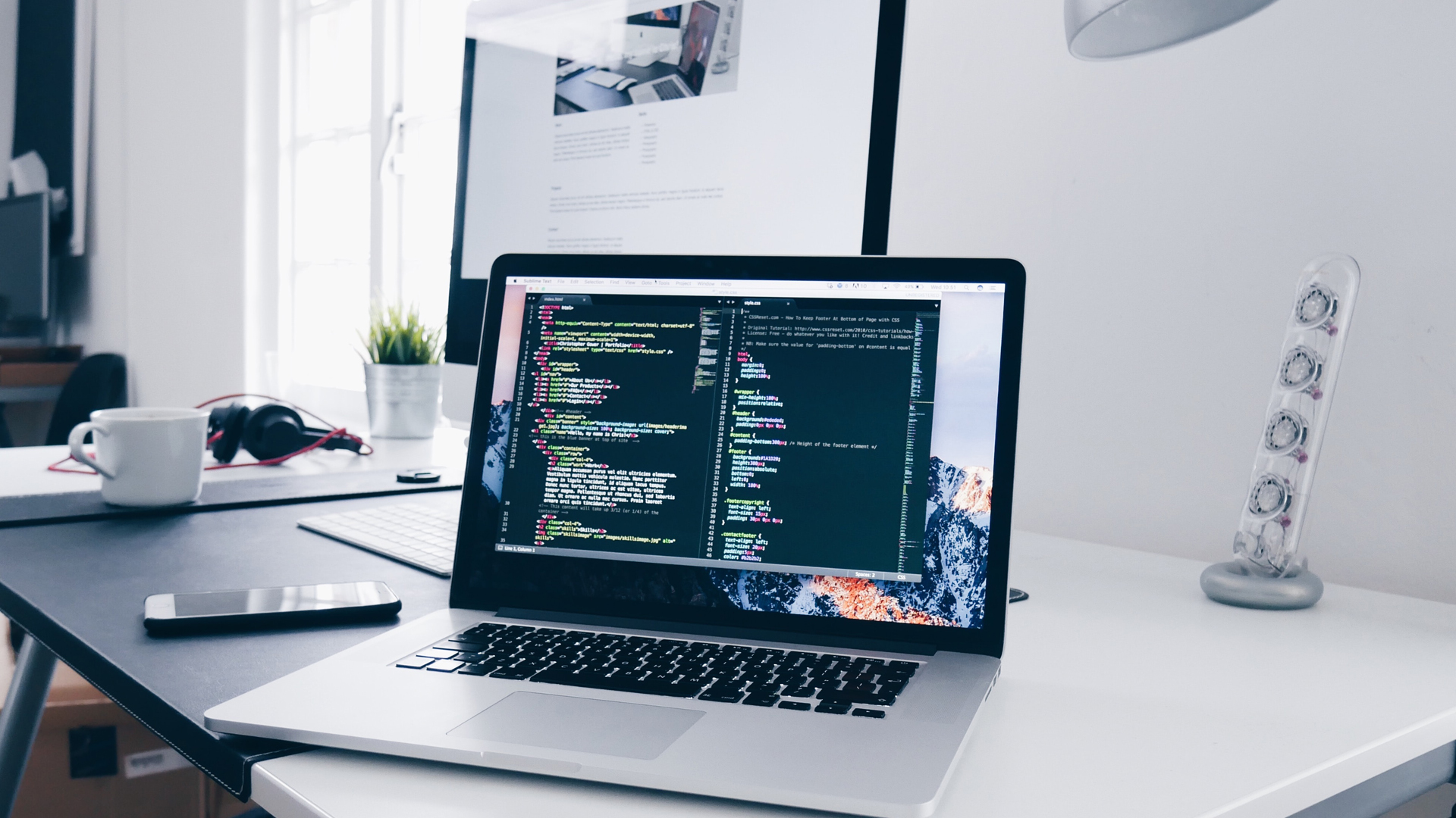 laptop open on desk displaying code