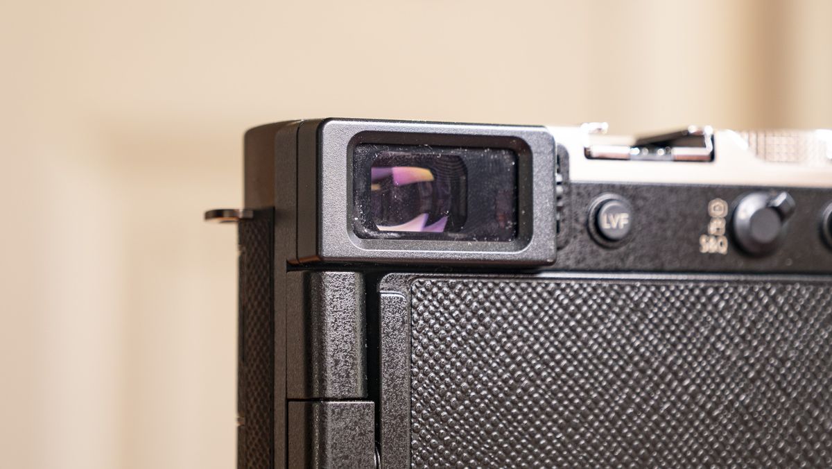 Close up of the viewfinder of the Titanium Gold special edition of the Panasonic Lumix L10 compact camera, on an antique wooden table