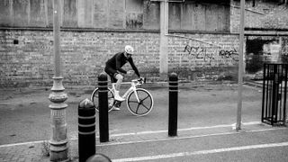 a black and white picture of bradley wiggins down an alley on a factor ostro VAM