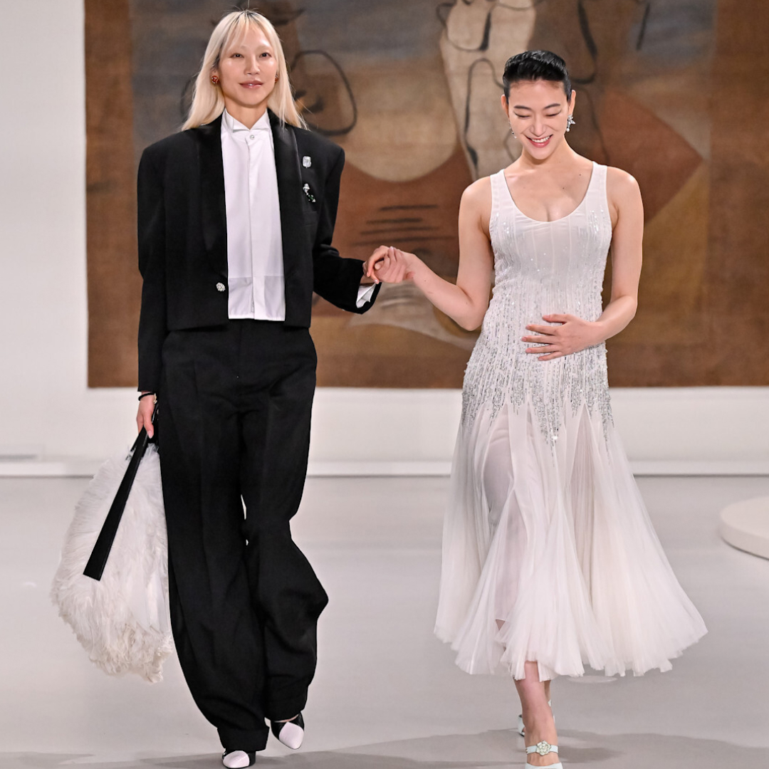 a model walks Chanel's Metiers d'Art runway while holding her pregnant stomach