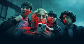 Nogle af hovedpersonerne i Netflix-serien Red Rose stirrer forfærdet på en mobiltelefon.