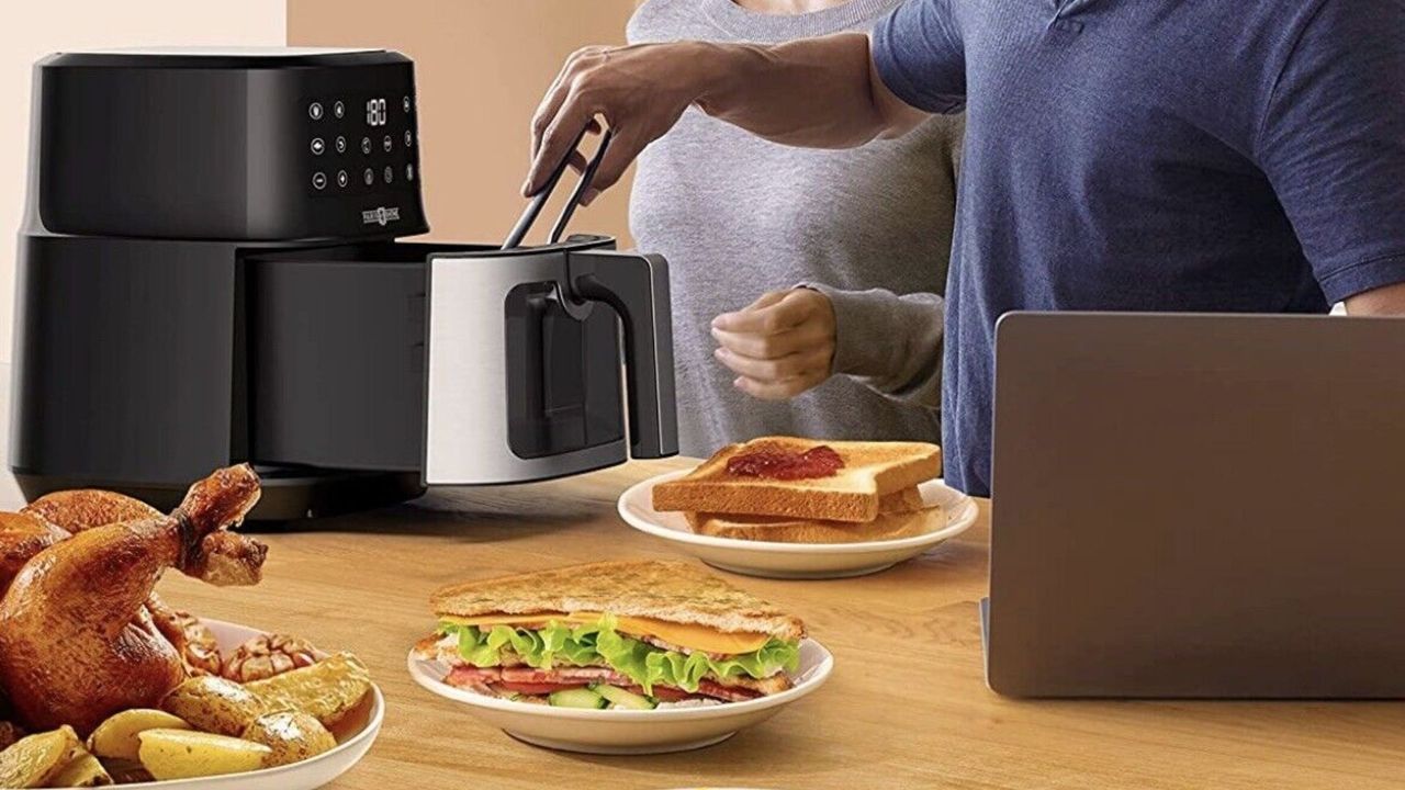 A Paris Rhône air fryer on a table with food around it