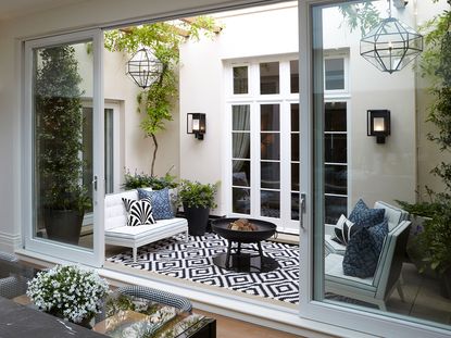 courtyard garden ideas - outdoor living room with rug and outdoor lighting