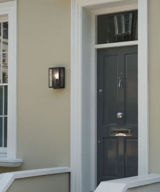 gray modern front door with contemporary wall light