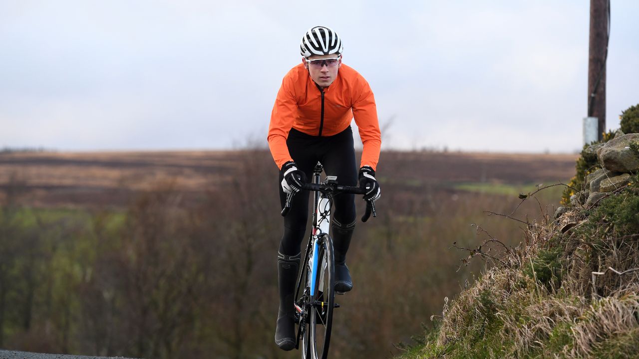 Image shows a rider cycling through the winter