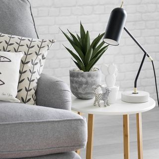 white round table with grey plant pot and lamp
