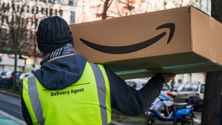 An Amazon delivery agent carrying an Amazon shipping box in Berlin, Germany, January 2020.