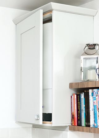 Close up photo of a boiler in a kitchen cupboard