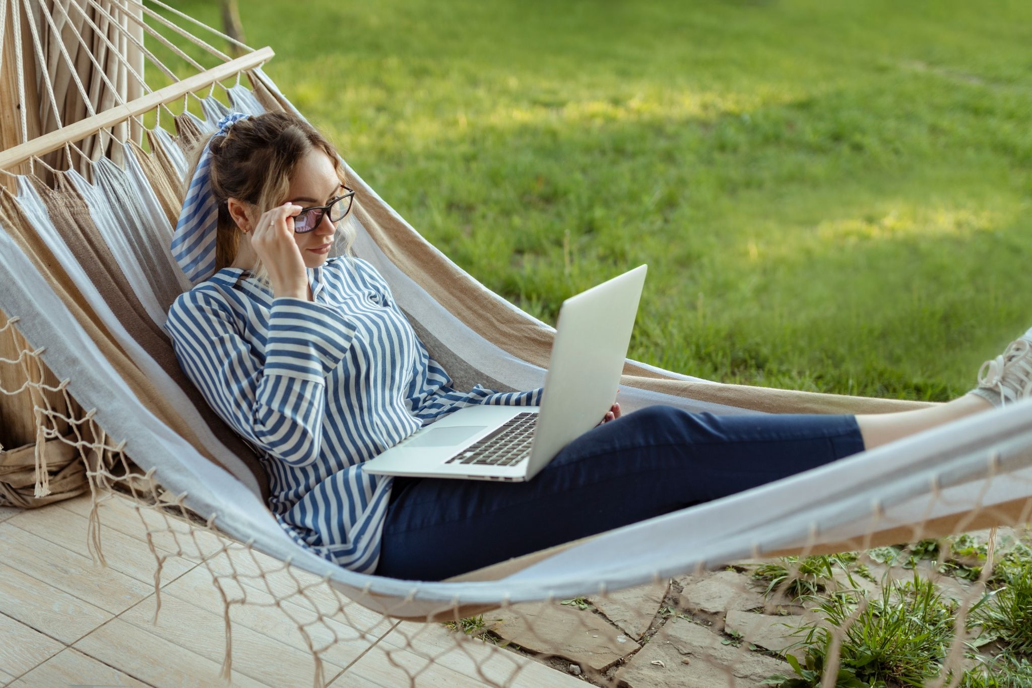 Woman in a hammock looking at a laptop