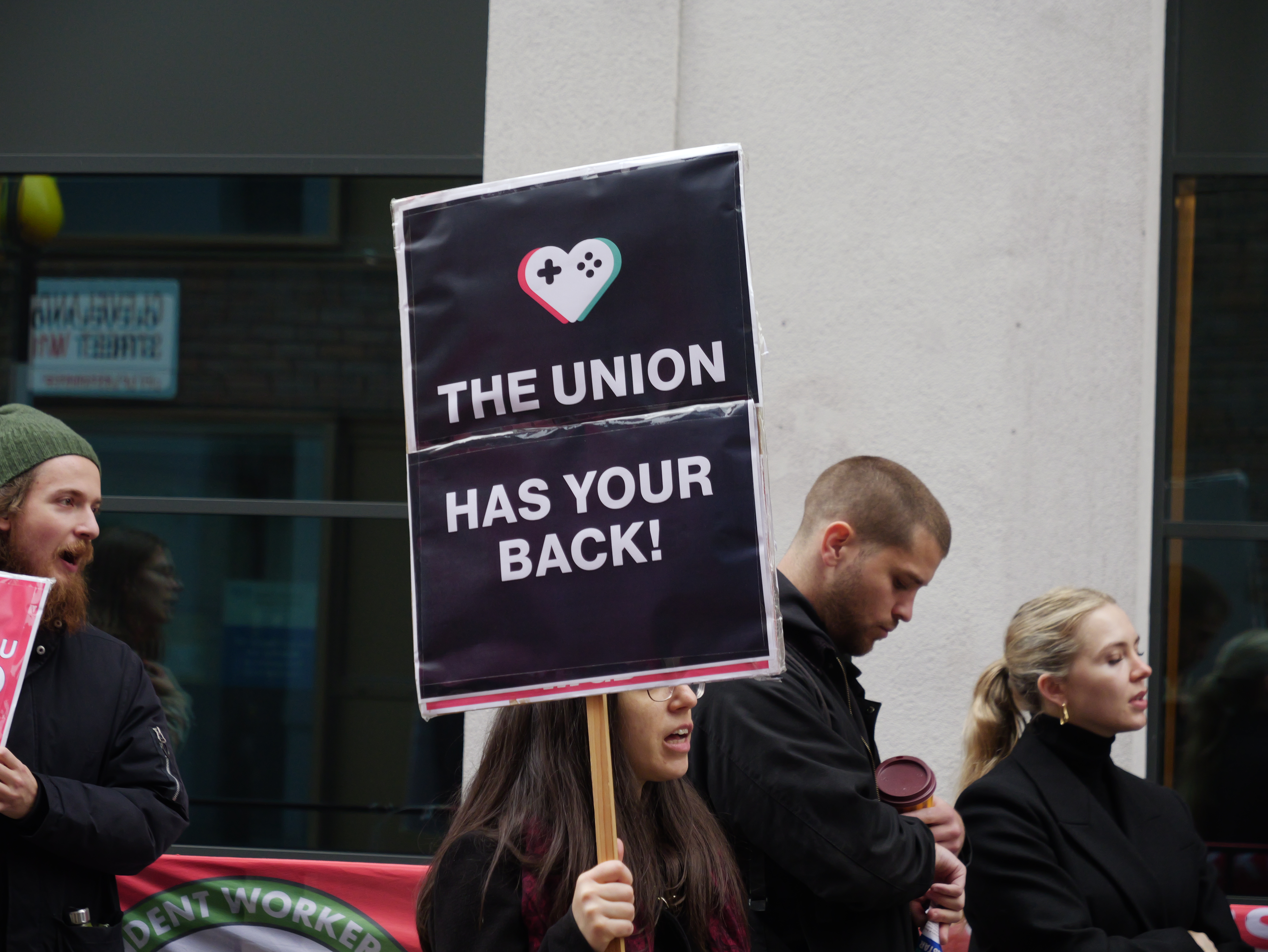 A protestor with a placard reading 'The union has your back!'