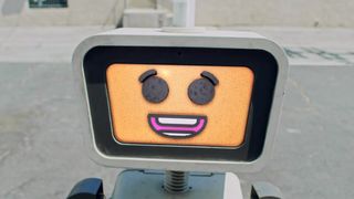 A small robot with smiling digital face.