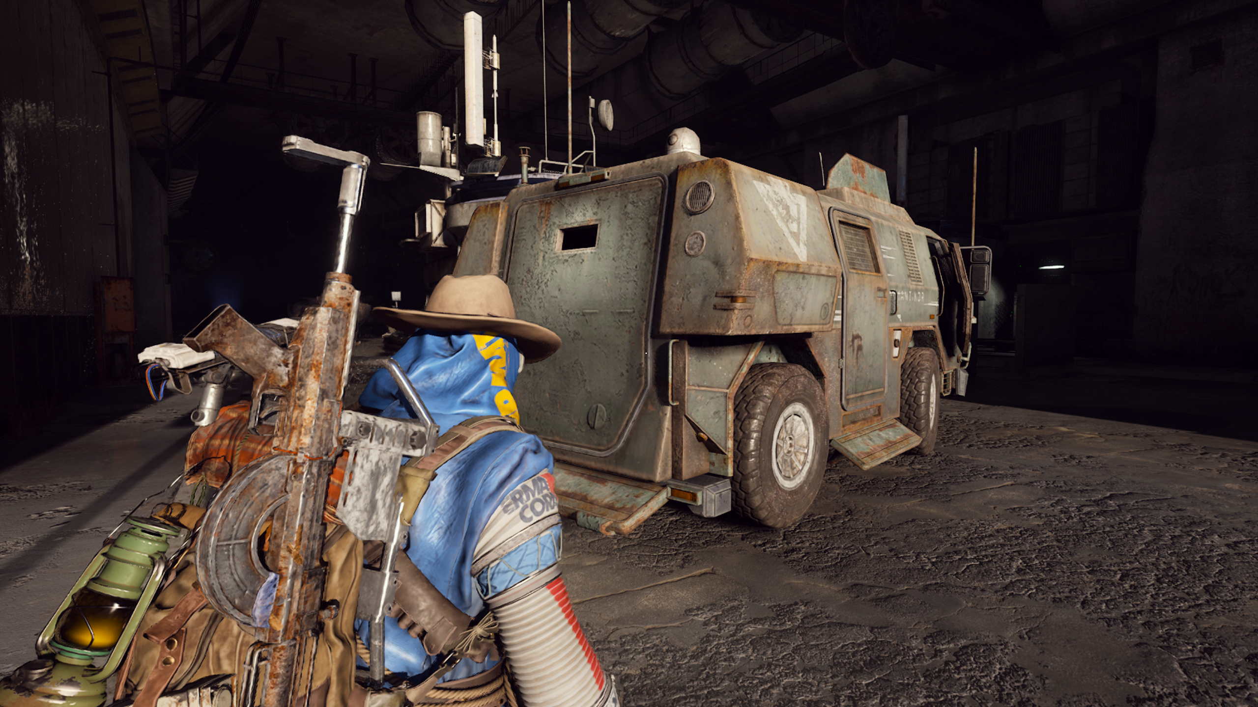 Arc Raiders Armored Transports: A player wearing a blue poncho and a cowboy hat looking at the back of an armored patrol car in the entryway to the Checkpoint tunnels.