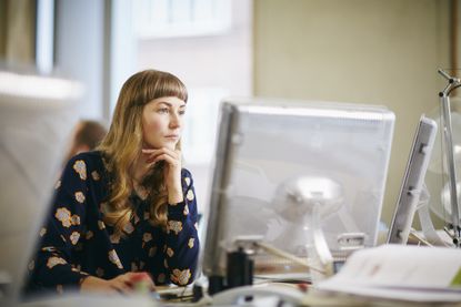 Overtime pay: A woman in an office looks worried and over-worked