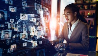 A woman at a laptop with a floating image of zero-trust image profiles.