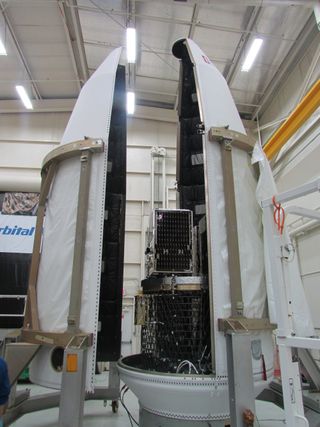 A suite of SkySat and Dove satellites is encapsulated into the payload fairing of an Orbital ATK Minotaur-C rocket prior to launch.