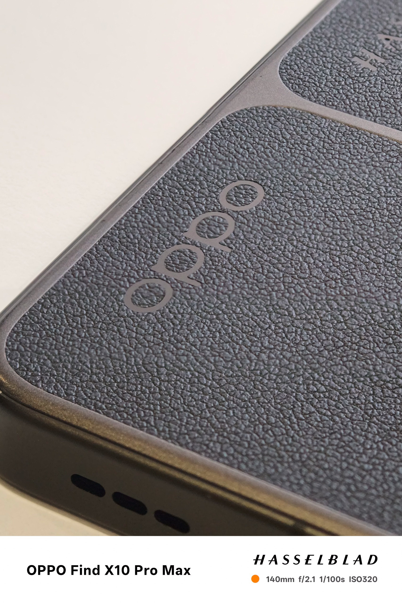 Close-up of an Oppo logo on a dark textured phone back.