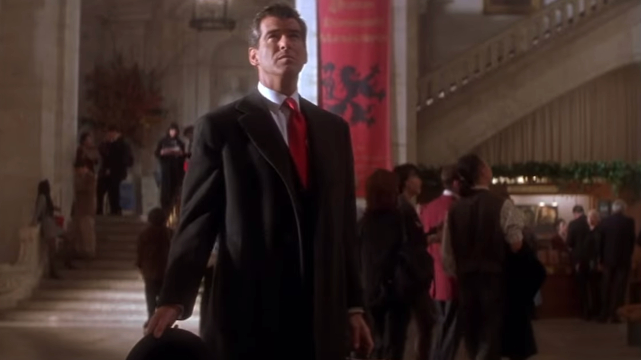 Pierce Brosnan stands well dressed in the museum lobby in The Thomas Crown Affair.