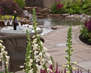 paved patio overlooking pond and waterfall feature
