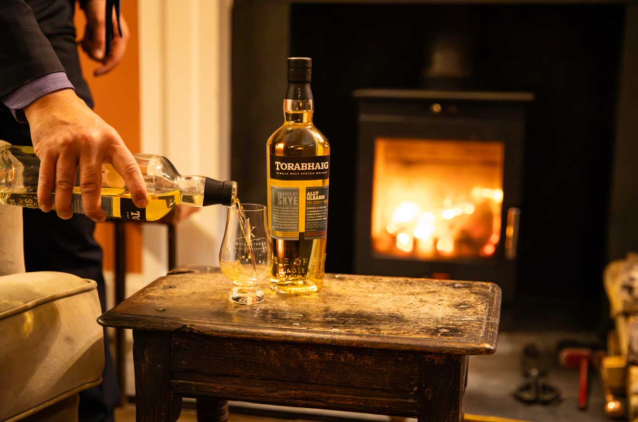 Pouring Torabhaig Whisky in front of an open fire