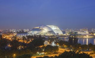 Dome shaped sports hub lit up at night