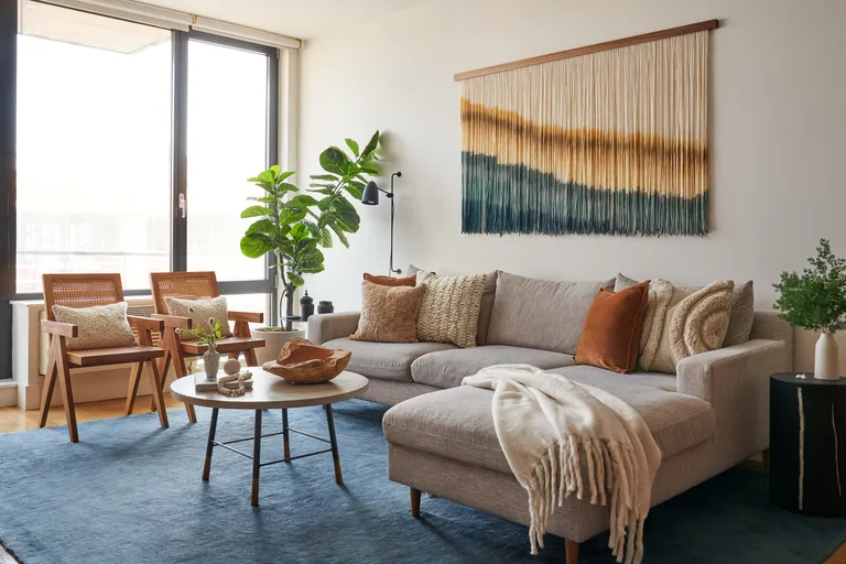 A living room with velvet and woven pillows