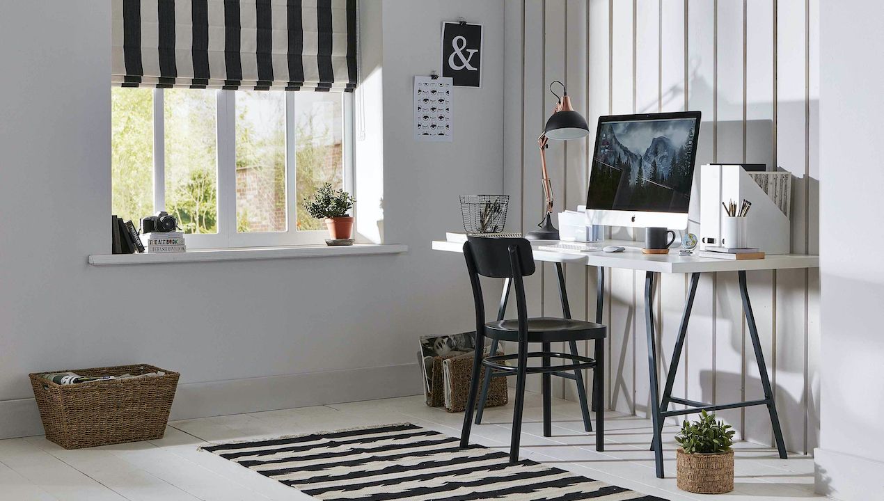 home office with small desk and striped blinds 