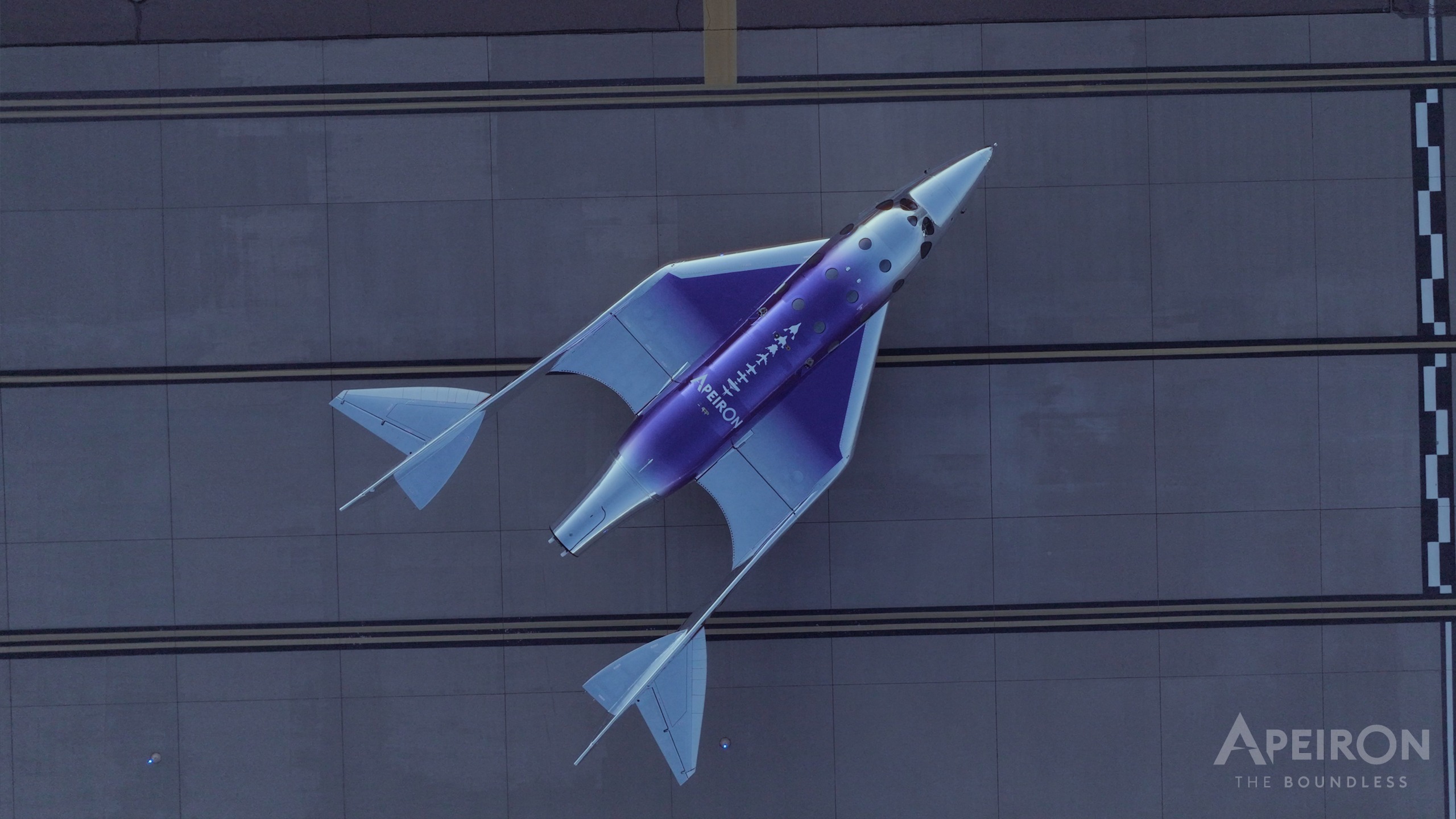 A space plane seen from above sitting on a runway.