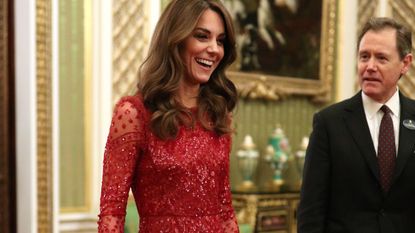 Catherine, Duchess of Cambridge walks through to the State Room with the Master of the Household during a reception to mark the UK-Africa Investment Summit at Buckingham Palace on January 20, 2020 in London, England