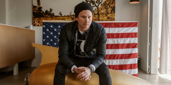 Tom DeLonge sat in front of an American flag