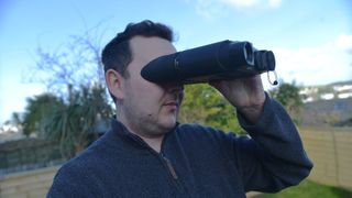 A reviewer using the NightFox Corsac, one of the best binoculars with a camera