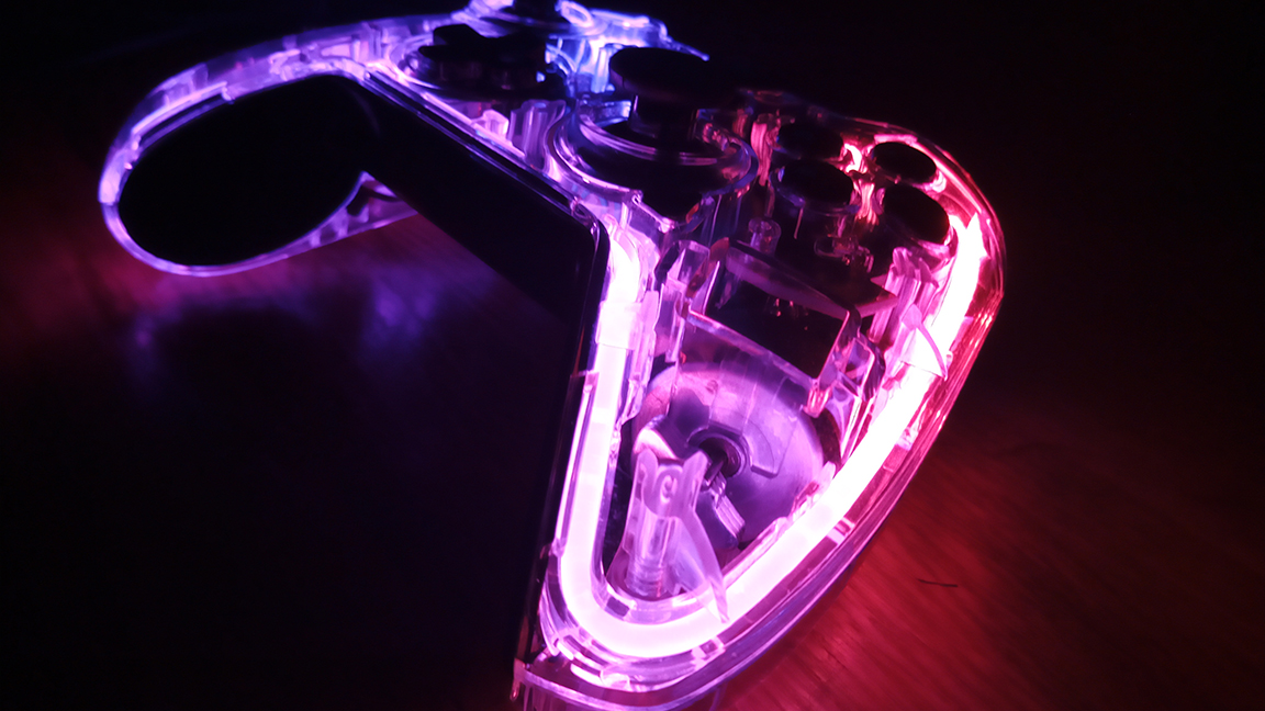 A photo of the BigBig Won Rainbow controller on a table glowing pink