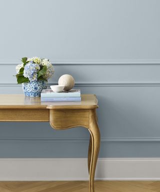 blue wall with wooden dresser