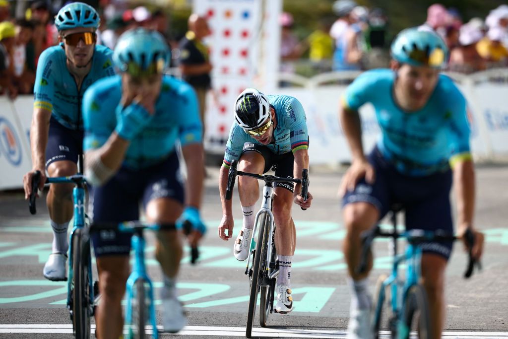 Astana Qazaqstan Team&#039;s British rider Mark Cavendish (C) flanked by teammates cycles to the finish line of the 15th stage of the 111th edition of the Tour de France cycling race, 197,7 km between Loudenvielle and Plateau de Beille, in the Pyrenees mountains, southwestern France, on July 14, 2024. (Photo by Anne-Christine POUJOULAT / AFP)