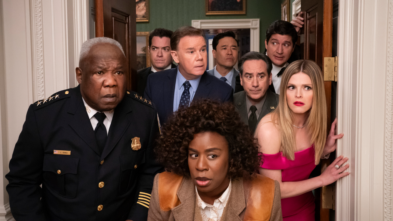 a group of people led by uzo aduba as detective cordelia cupp peek through a doorway in a still from the tv show the residence