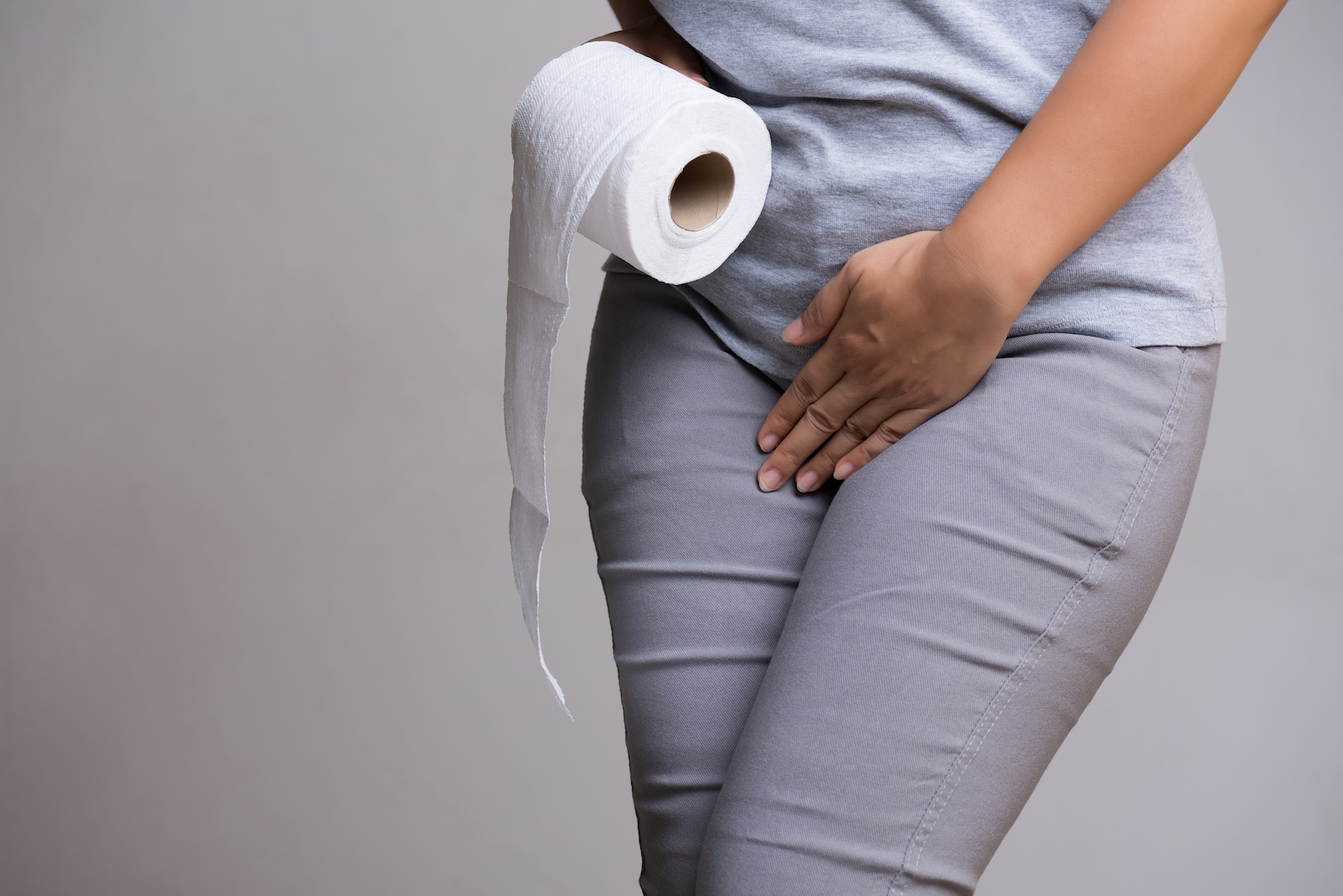 bottom half of woman with toilet paper roll needs to pee