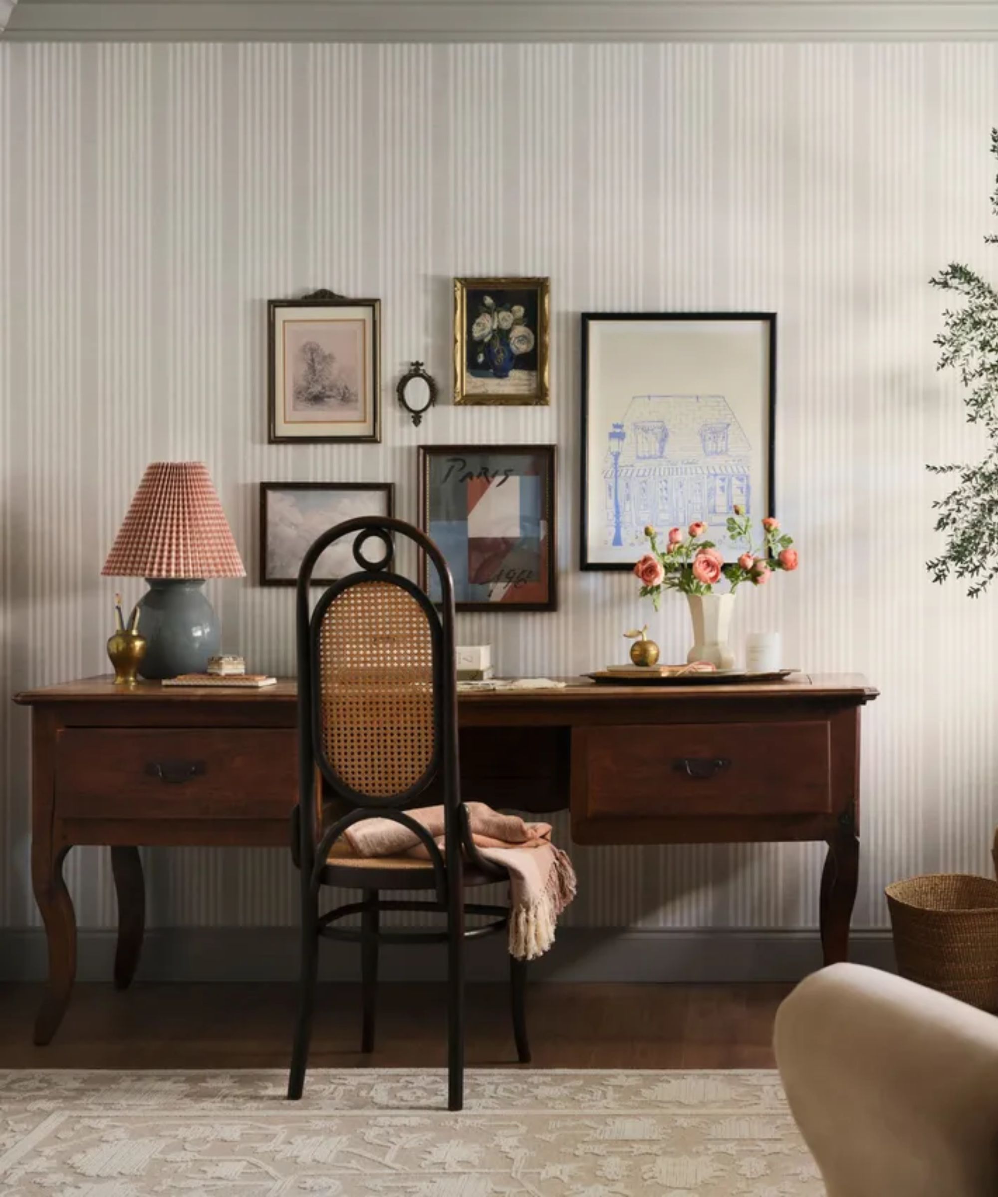 home office from joanna gaines' mini reni TV makeover show with a large dark wooden desk, striped wallpaper and a gallery wall