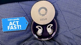 Ozlo Sleepbuds in silver circular case on blue and white patterned blanket