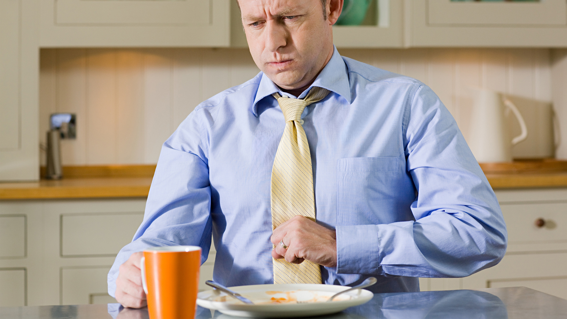 man experiencing GERD (acid reflux) as he eats