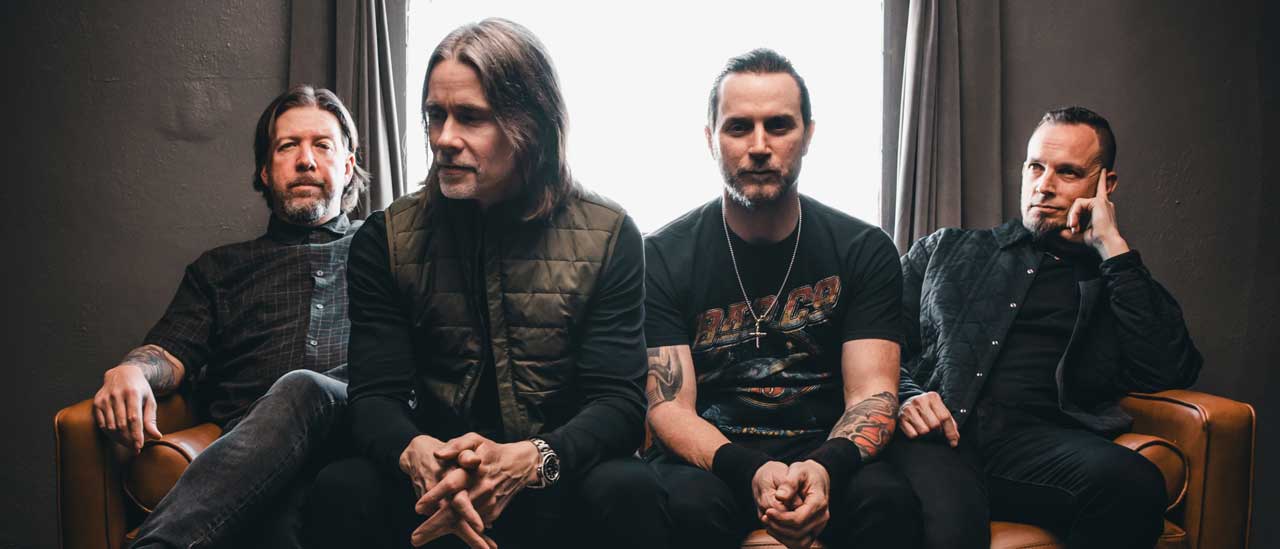 Alter Bridge sitting in front of a window