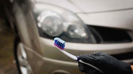 toothbrush with toothpaste in front of car headlights