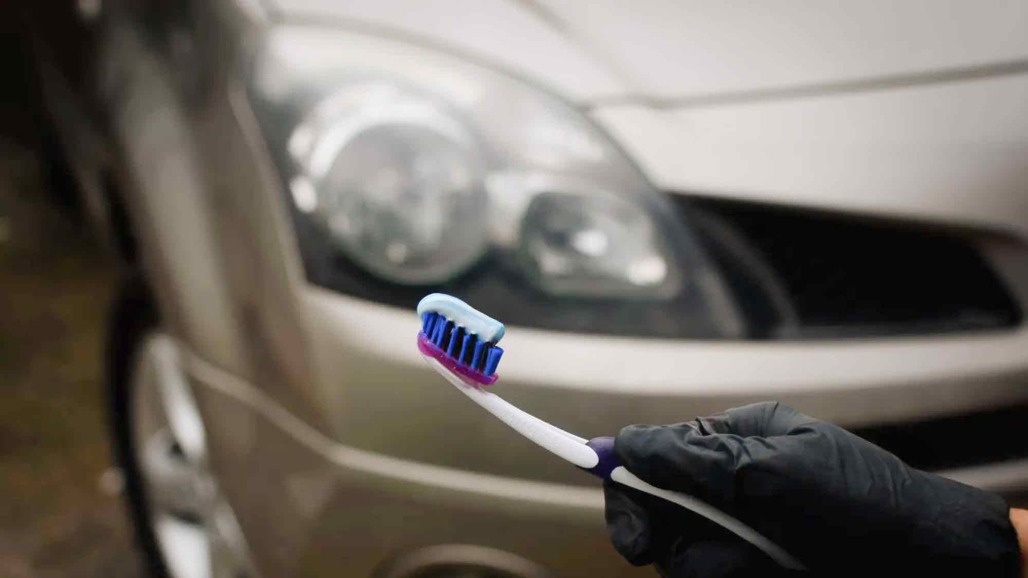 toothbrush with toothpaste in front of car headlights