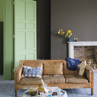living room with green door wooden flooring and brown sofa set