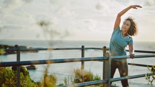 Woman stretching on walkway by the sea