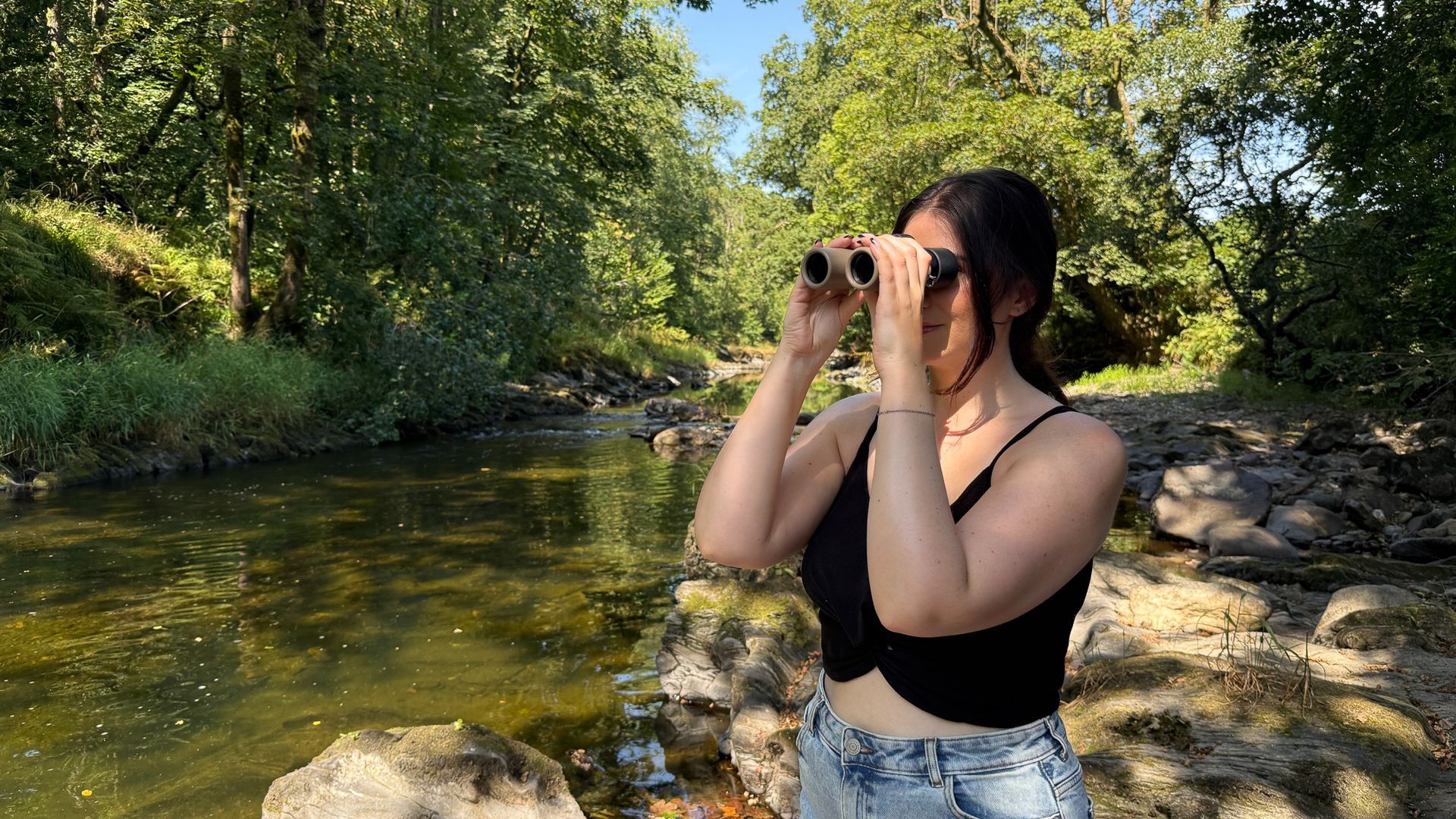woman using the Swarovski CL Companion 8x30 by a river