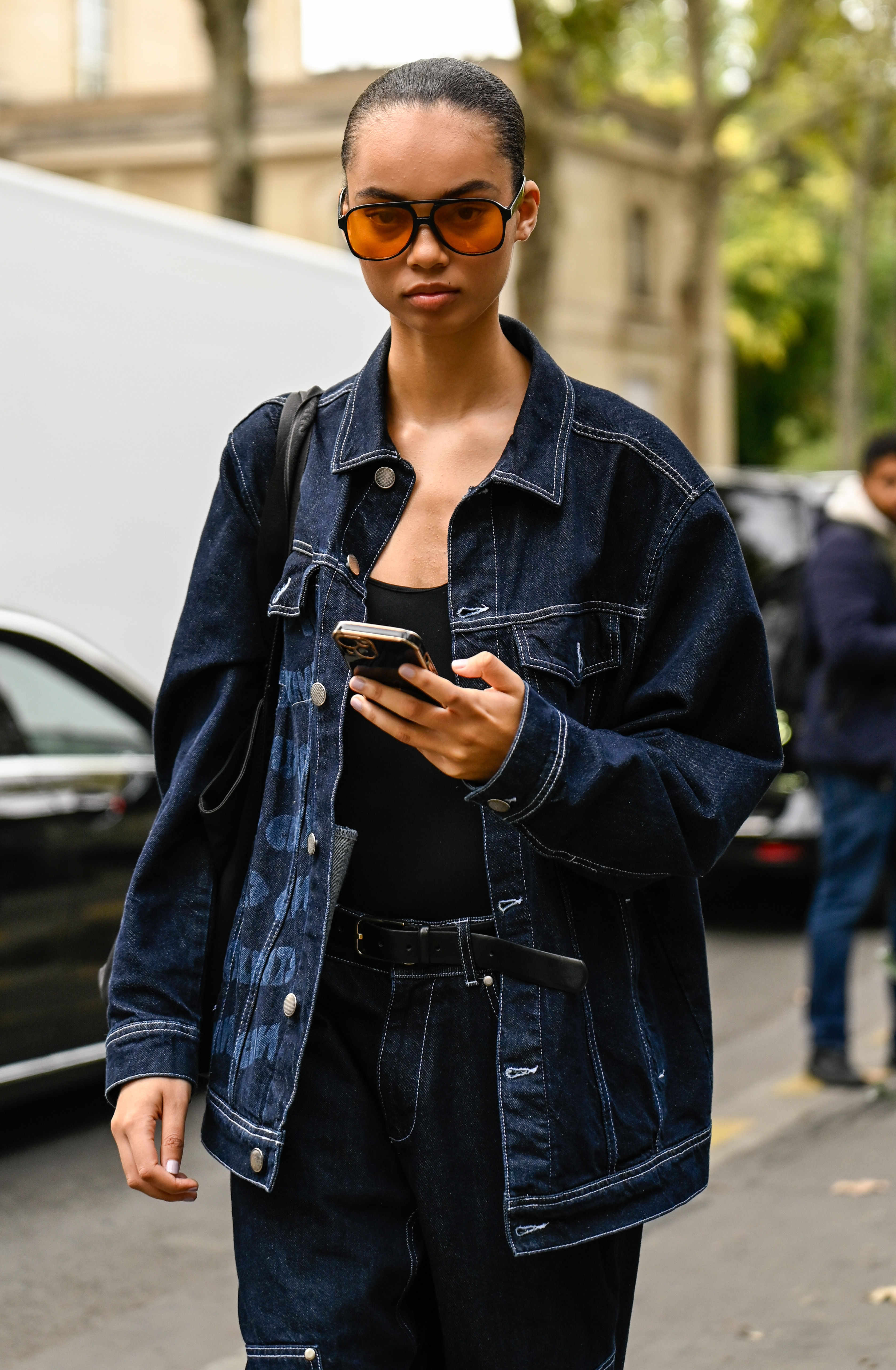 Person wearing a denim jacket during Paris Fashion Week.