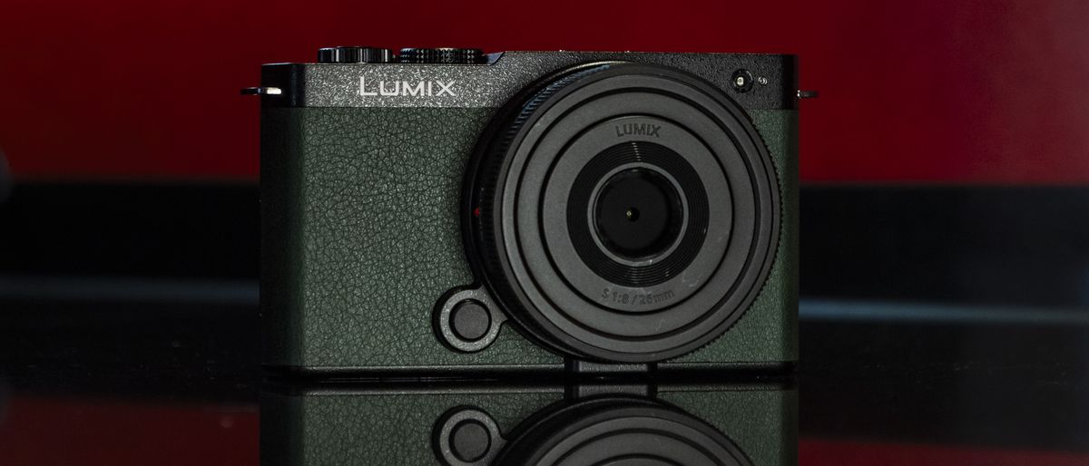 Panasonic Lumix S9 camera in Dark Olive color on a rich red reflective surface