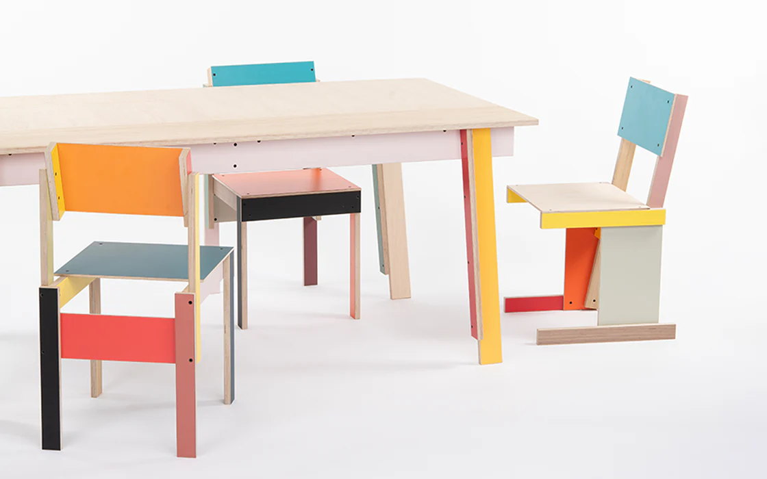 A series of colorful wooden furniture including a table and chairs.