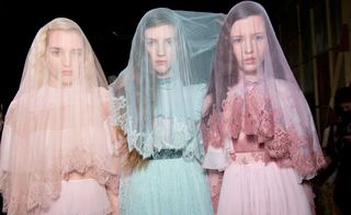 Three women in pastel-coloured wedding dresses and veils