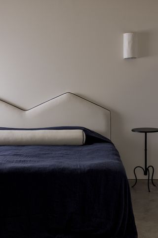 A bed with a headboard and bolster cushion