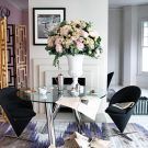 white dining room with glass top table and white flower vase